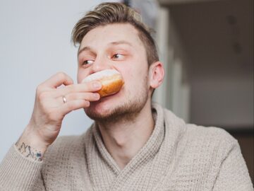 Mężczyzna je pączka