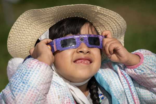 A young girl puts on a pair of solar-viewing glasses to view the partial solar eclipse from the National Mall in Washington, D.C., in April 2024. On Sept. 21, a partial solar eclipse will take place over a small corner of the globe. File Photo by Bonnie Cash/UPI
