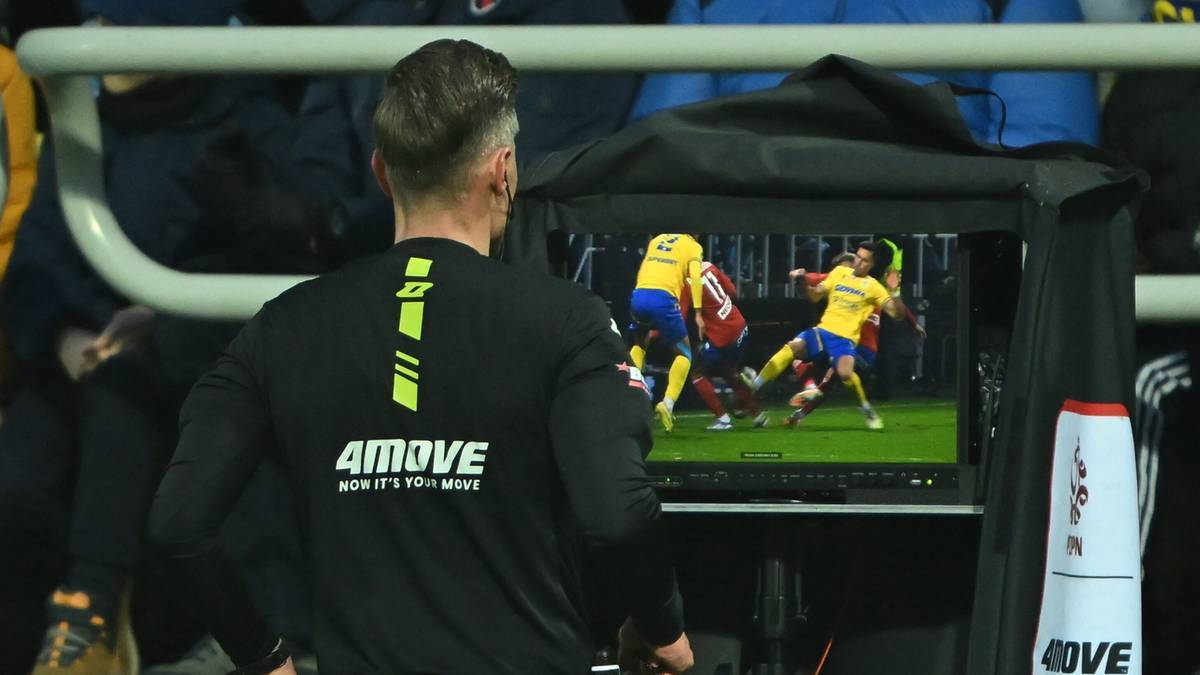 Sędzia ogląda powt&oacute;rkę na monitorze podczas meczu piłki nożnej.