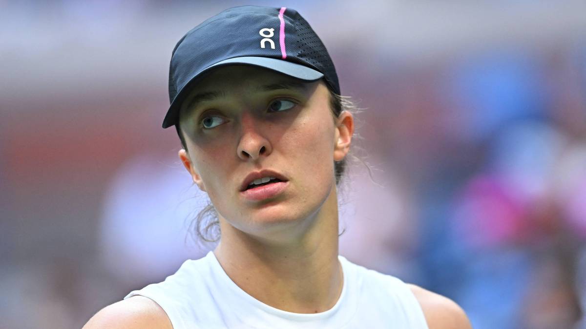 Zbliżenie na twarz Igi Świątek w czapce z daszkiem, patrzącej w bok z lekko zaniepokojonym wyrazem twarzy.