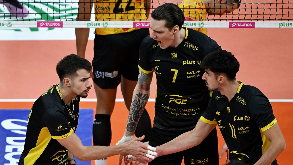 Trzech siatkarzy PGE GiEK Skry Bełchat&oacute;w podczas meczu, dw&oacute;ch z nich ściska sobie dłonie.