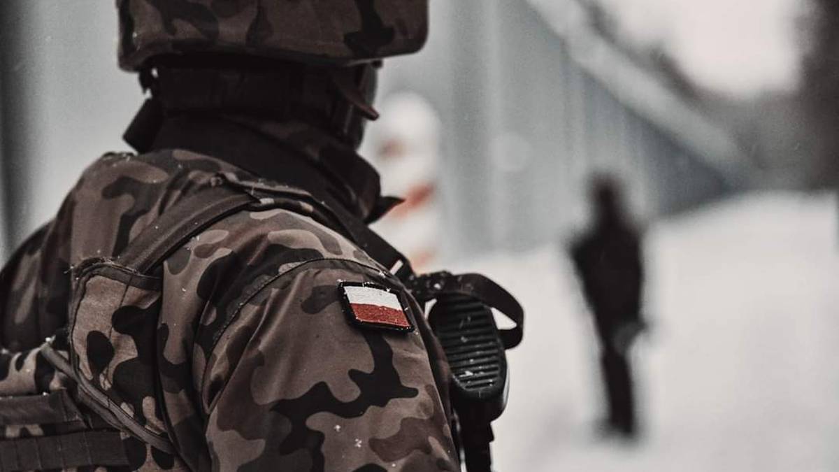 Żołnierz Wojska Polskiego w mundurze z naszywką polskiej flagi na ramieniu.