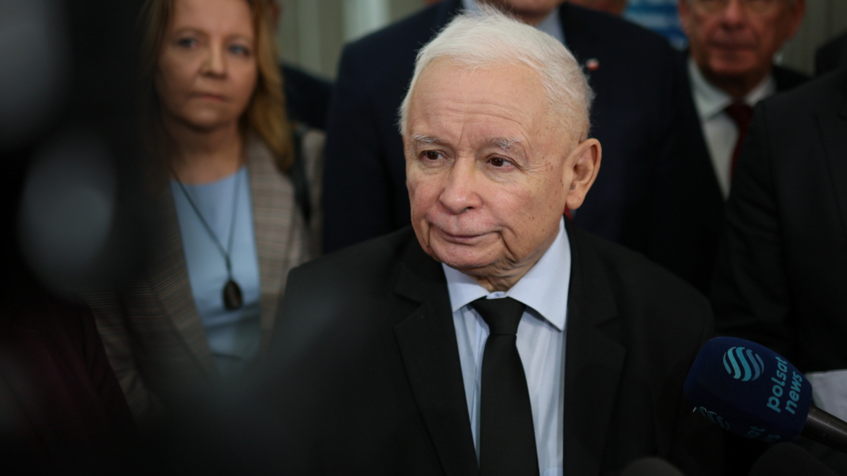 Jarosław Kaczyński w garniturze z krawatem, z mikrofonem Polsat News na pierwszym planie.