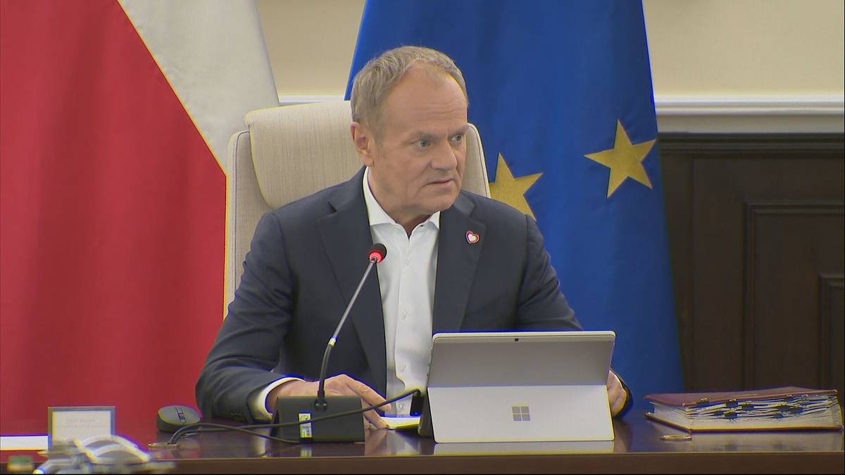 "Sprzecznie z polską racją stanu." Tusk oburzony po odjeździe Nawrockiego 3 Premier Donald Tusk siedzi przy biurku z laptopem, w tle flagi Polski i Unii Europejskiej.