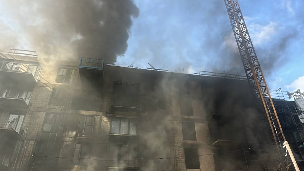 Ogień na fasadzie budynku w Białołęce. Zadymienie widoczne z centralnej Warszawy. 3 Płonąca elewacja budynku w budowie na Białołęce, w tle widoczny żuraw budowlany i unoszący się czarny dym.