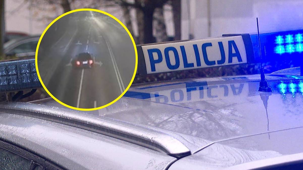 Policyjny radiow&oacute;z z włączonymi niebieskimi światłami.