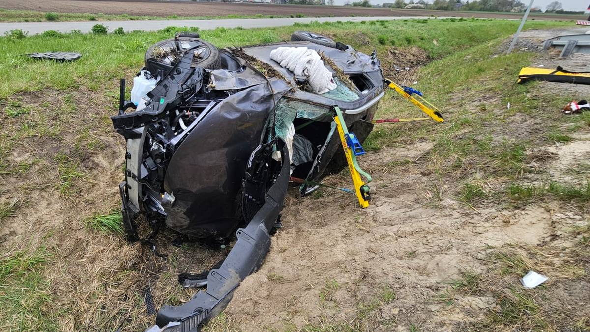 Uszkodzony samoch&oacute;d leżący w rowie po wypadku drogowym.