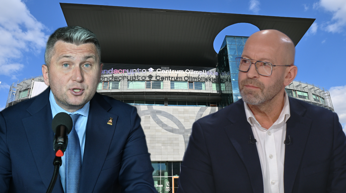 Dw&oacute;ch mężczyzn w garniturach, jeden z nich m&oacute;wi do mikrofonu, w tle nowoczesny budynek