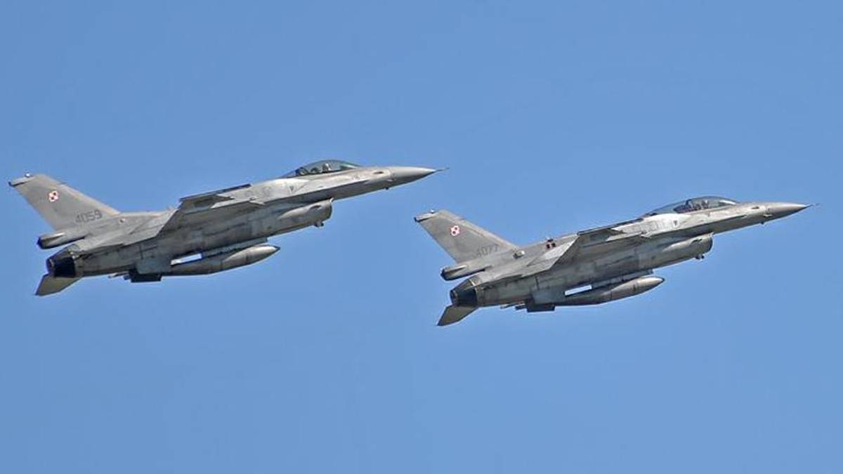 Dwa polskie myśliwce F-16 lecące na tle błękitnego nieba.