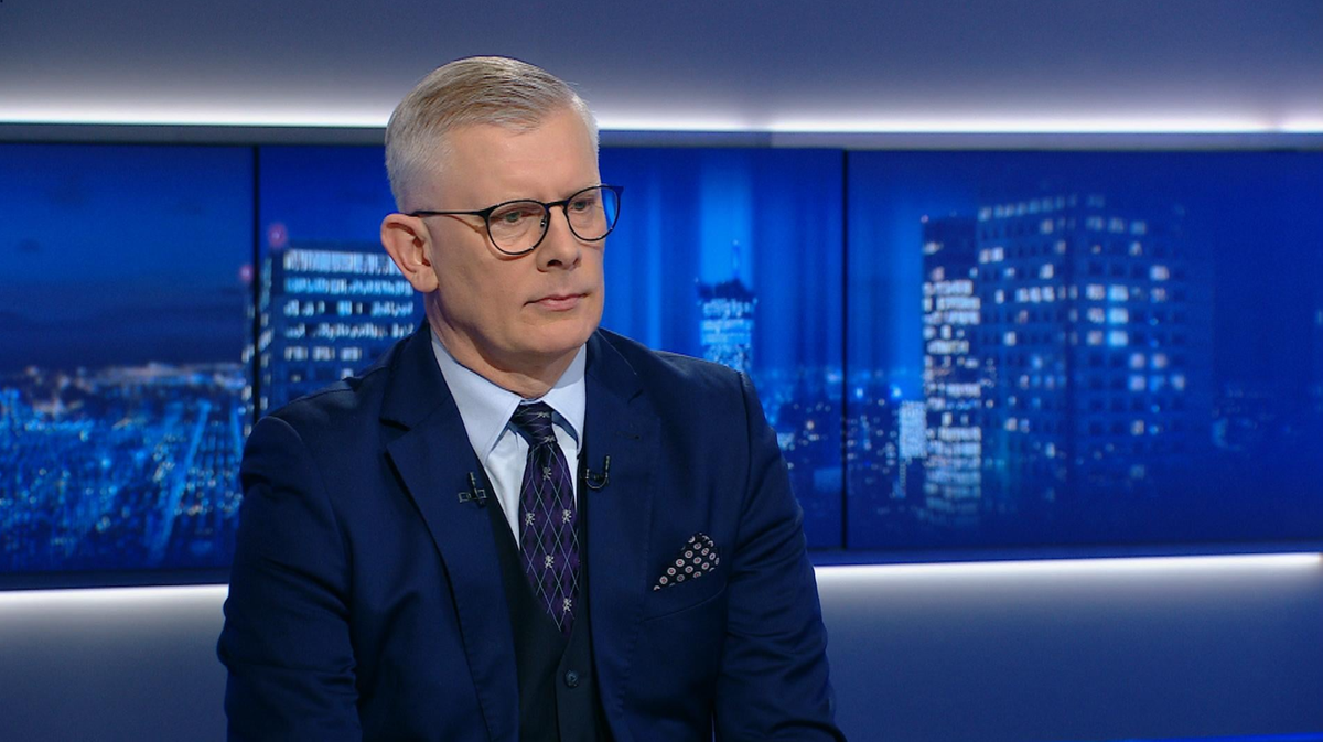 Sędzia Trybunału Konstytucyjnego Krystian Markiewicz w garniturze i okularach, siedzący w studiu telewizyjnym.