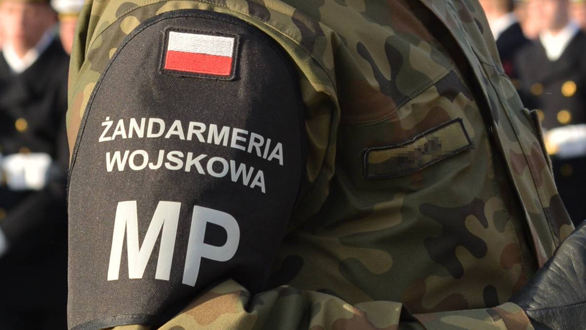 Fragment munduru Żandarmerii Wojskowej z naszywką z flagą Polski i napisem "ŻANDARMERIA WOJSKOWA MP"