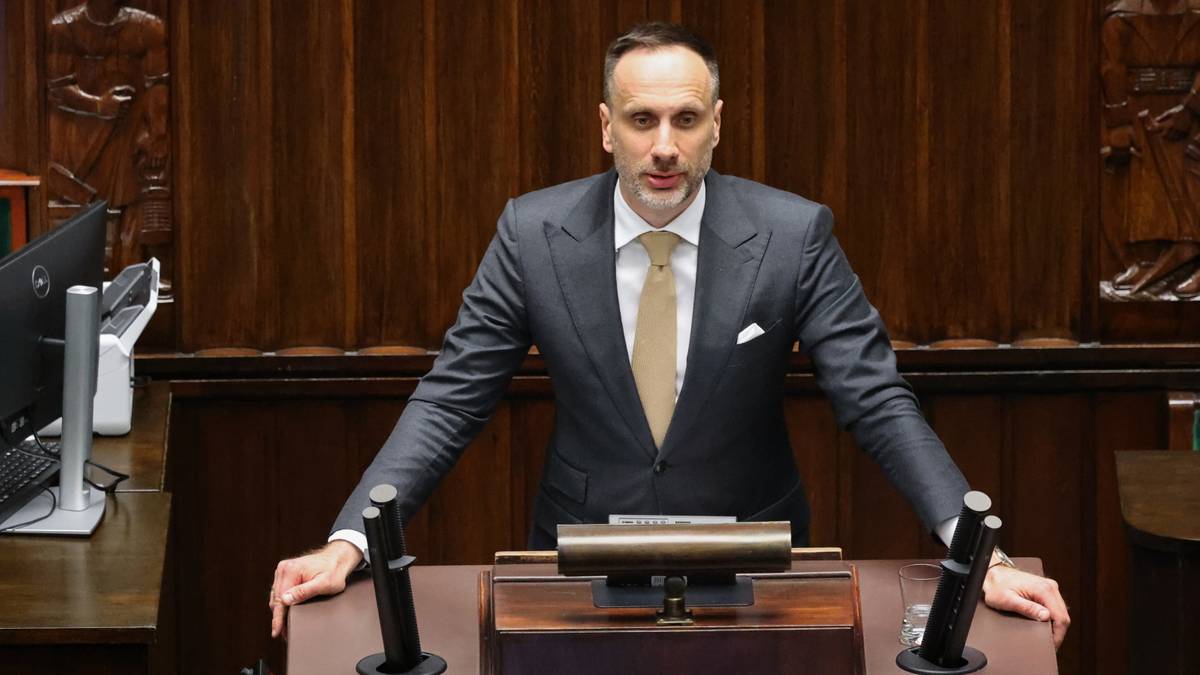 Poseł Janusz Kowalski stojący przy m&oacute;wnicy w sali sejmowej.
